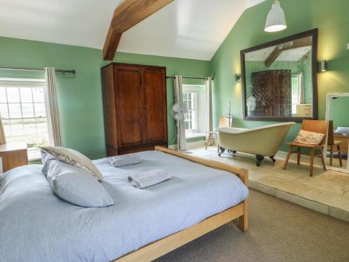 a bedroom with a large bed and a bath tub at Clynnog House in Dwyran