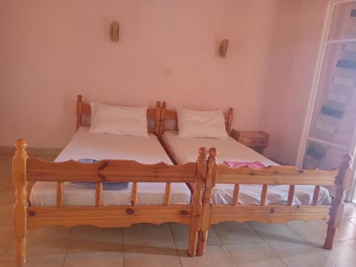 a bedroom with a wooden bed in a room at Corfu sunrise sea view apartments 100m from the beach in Benitses