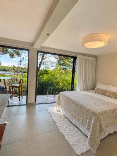 a bedroom with a bed and a large window at Pousada Mangue Seco in Itaúnas