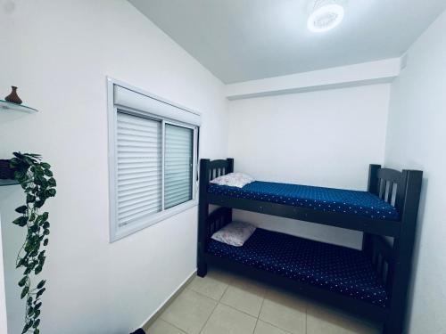 a black shelf in a room with a window at Apto frente o mar com 3 piscinas Wi-Fi gratuito aceito pet in Mongaguá