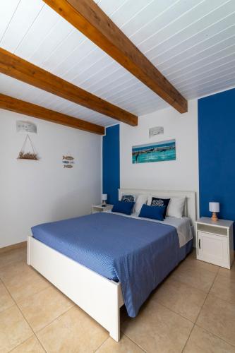 a bedroom with blue walls and a large bed at Poseidonia nel Borgo in Pulsano