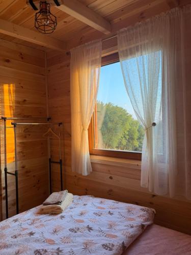 a bedroom with a bed and a large window at Bukuria e Fjerinës in Ulcinj
