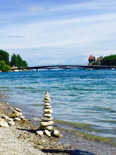 a stack of rocks on the shore of the water at Rheinblick Riverview Luxury in Konstanz