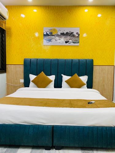 a bed with a blue headboard in a room at The Commune Varanasi in Varanasi