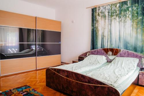 a bedroom with a bed with a large wooden headboard at Casa Verde in Vaţa de Jos