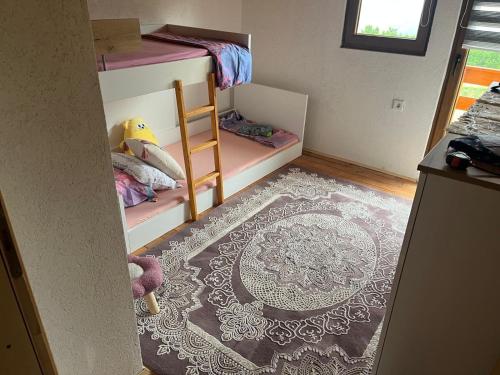 a room with two bunk beds and a rug at Planinska Idila in Vareš