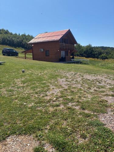 a house with a grass field in front of it at Planinska Idila in Vareš
