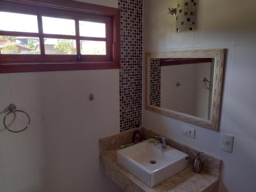 a bathroom with a sink and a mirror at Refúgio do Jaguari in Piracaia
