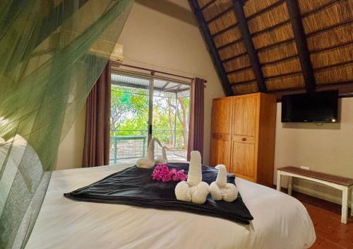 a bedroom with a bed with three stuffed animals on it at Ngandu Hotel - Rundu in Rundu