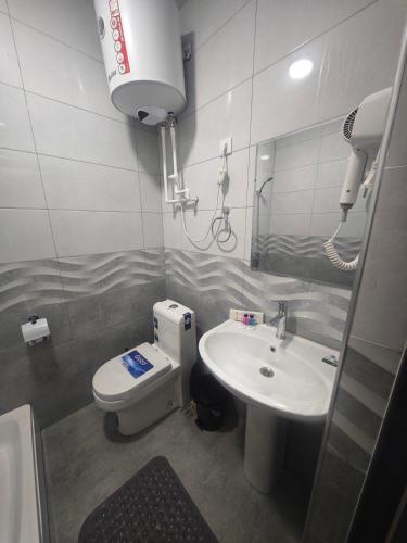 a bathroom with a toilet and a sink at Baxt Hotel&Hostel in Andijan