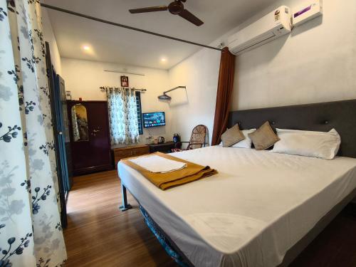 a bedroom with a large bed with a ceiling at CloudHill Retreat in Ariankāvu