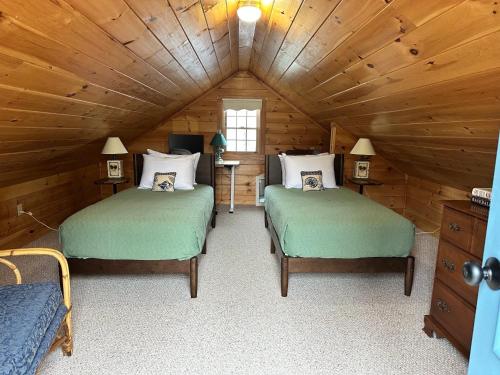 a bedroom with two beds in a wooden cabin at Capstone Cottage - Quintessential Cabin on Bay in Gouldsboro