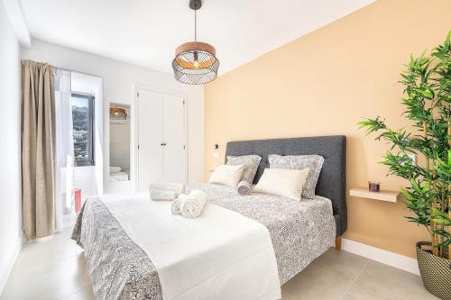 a bedroom with a large bed with white sheets and pillows at Casa Arizona Central Duplex Puerto Rico GC in Mogán