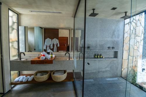 a bathroom with a glass shower and a sink at NANNAI Milagres in São Miguel dos Milagres