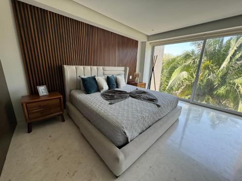 a bedroom with a bed and a large window at Departamento Diamante Azul Punta Mita, Beach Front in Punta Mita