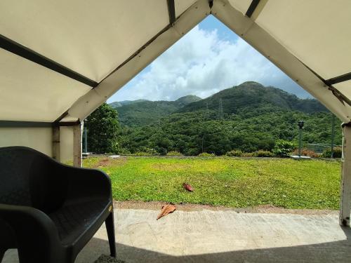a window with a view of a field and mountains at CloudHill Retreat in Ariankāvu