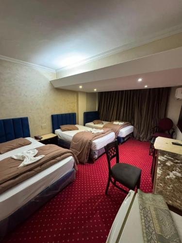 a hotel room with three beds and a chair at Verssailles Al Manar Hotel in Cairo