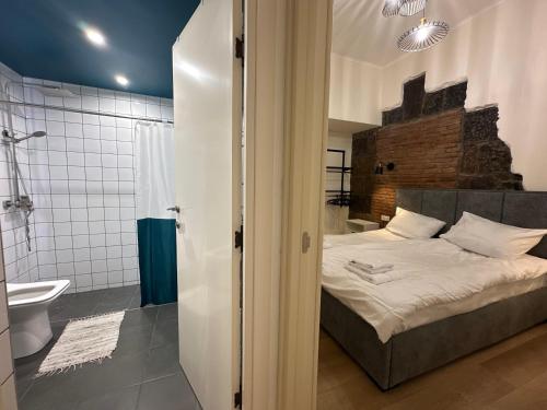 a bedroom with a bed and a bathroom with a shower at Communa Guesthouse in Gyumri