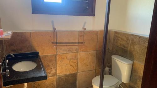 a bathroom with a toilet and a sink at Ondas do mar Taiba Residence in Taíba