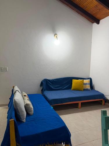 a room with two beds and a blue couch at Refúgio a 100m da Praia Conforto e Lazer Completo in Prado