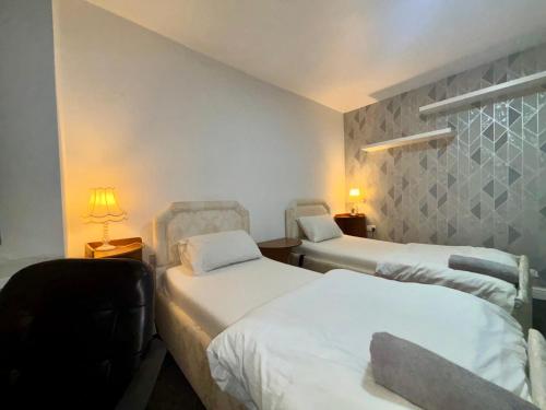 a hotel room with two beds and two lamps at HomesRentals in Dudley