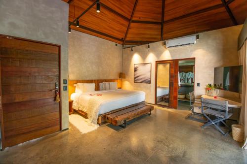 a bedroom with a bed and a desk and a door at NANNAI Milagres in São Miguel dos Milagres