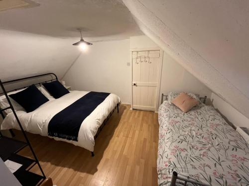a bedroom with a bed and a ladder in a attic at Hallow Cottage in Newtownstewart