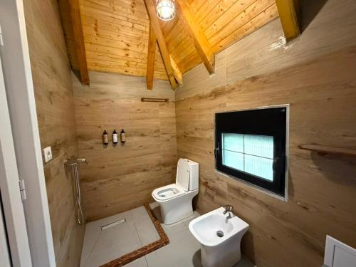 a wooden bathroom with a toilet and a sink at Villa Bushati in Tropojë