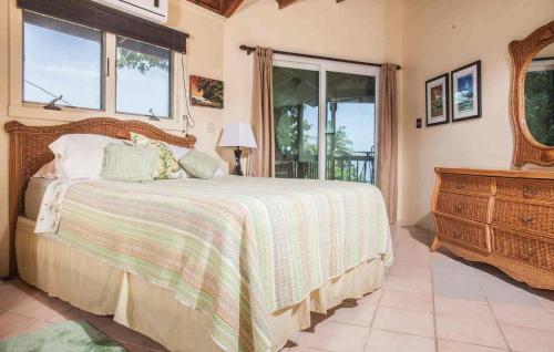 a bedroom with a bed and a dresser and windows at Tres Amigos Beach House, Rincon PR in Rincon