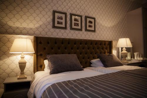 a bedroom with two beds and two lamps on tables at Dooly's Hotel in Birr