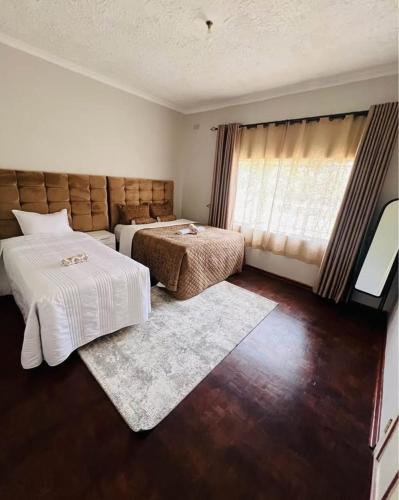 a bedroom with two beds and a window at BillGates BNB in Harare