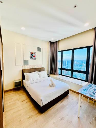 a bedroom with a bed and a table and windows at The Luxe Service Suites in Kuala Lumpur