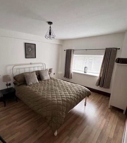 a bedroom with a large bed and a window at Hollins Mill Apartment in Sowerby Bridge