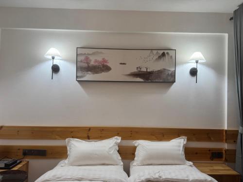 a bedroom with two beds and a picture on the wall at Whalesharkview in Maamigili