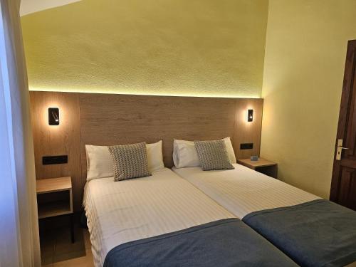 a bedroom with a large white bed with two pillows at Playamar Bungalows in Playa del Ingles