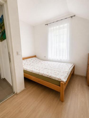 a bedroom with a bed in a room with a window at Guest House Ulnika in Vusanje