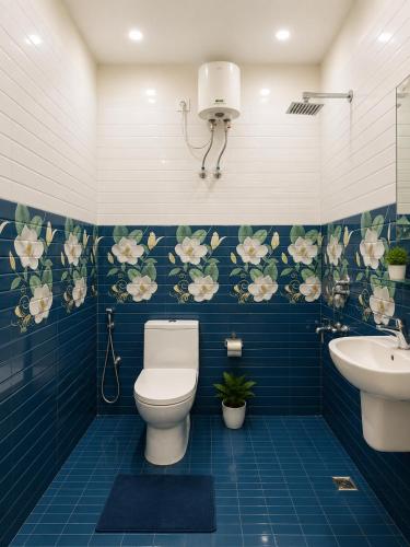 a bathroom with a toilet and a sink and blue tiles at Shree Ram Mandir 500m Walk - Atharav Palace in Ayodhya