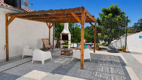 a wooden pavilion with a stove in a backyard at Villa Madalena in Coucieiro