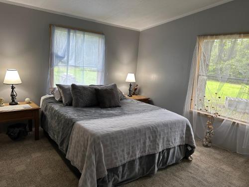 a bedroom with a bed and two windows at The Moseley-Smith Plantation SHARED LIVING Queen Bedroom in Aiken