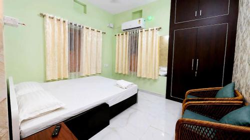 a small bedroom with a bed and a chair at R S Homestay in Deoghar
