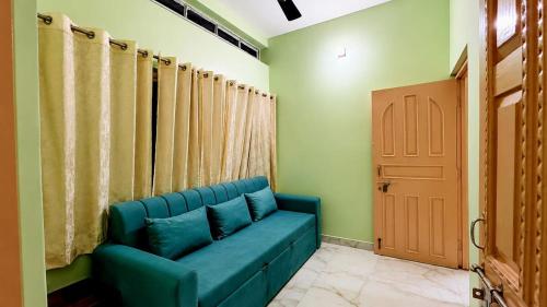 a blue couch in a room with a door at R S Homestay in Deoghar