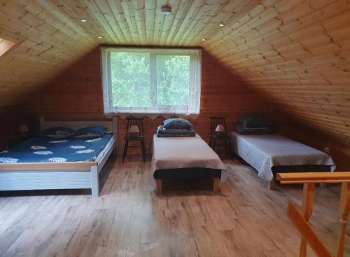 a room with two beds in a log cabin at Väike-Puusmetsa puhkemaja in Valtina