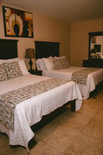 a hotel room with two beds and a mirror at Hotel Villa Bernal in Bernal