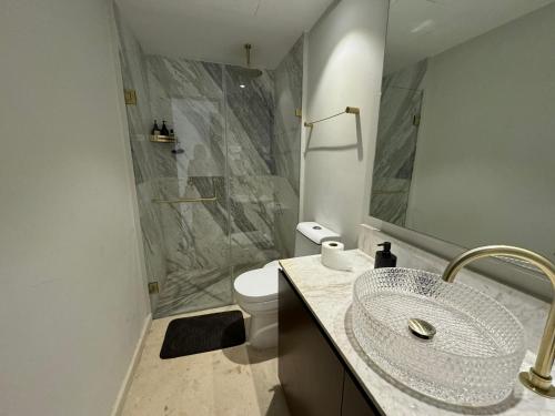 a bathroom with a sink and a shower and a toilet at Departamento Pacific Luxury Punta Mita, Beachfront in Higuera Blanca
