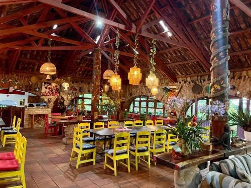 a dining room with yellow chairs and a table at cabañas de Apaneca in Apaneca