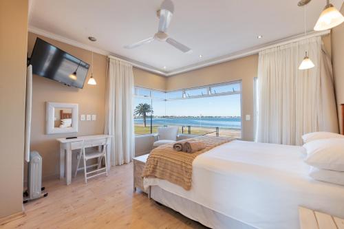 a bedroom with a large bed and a view of the ocean at Lagoon View Self Catering in Walvis Bay