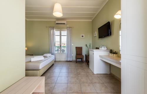 a room with a bed and a tv and a couch at Almyris in Adamantas