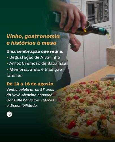 a person is cutting a pizza with a bottle of wine at Pousada e Adega Lapa do Lobo in Conservatória