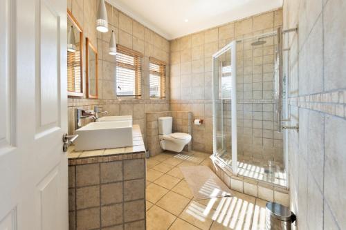 a bathroom with a toilet and a sink and a shower at Lagoon View Self Catering in Walvis Bay