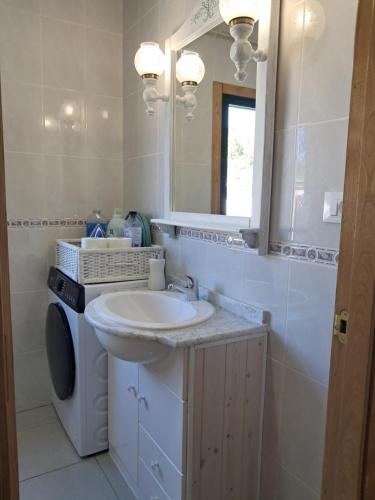 a bathroom with a sink and a washing machine at O LAR DO SIL - Ribeira Sacra in Villar de Cerreda
